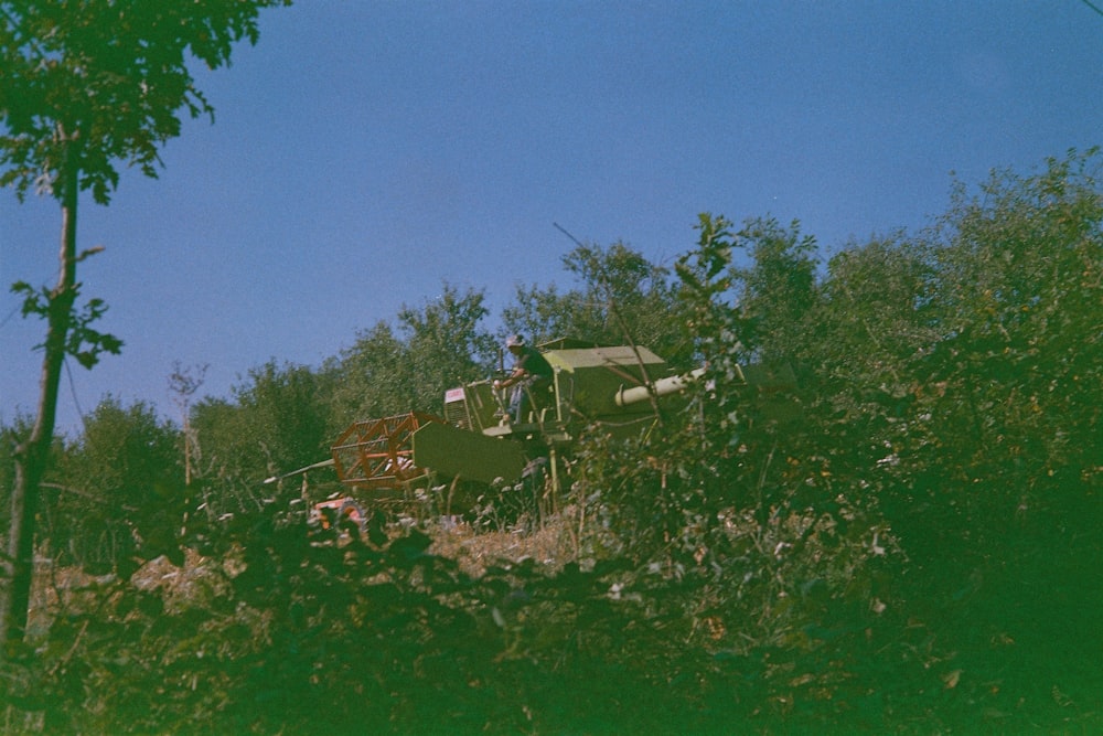 person on heavy equipment surrounded by trees