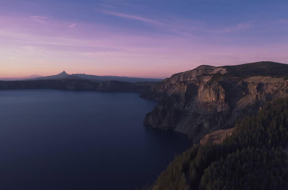 body of water under clear sky during golden hour