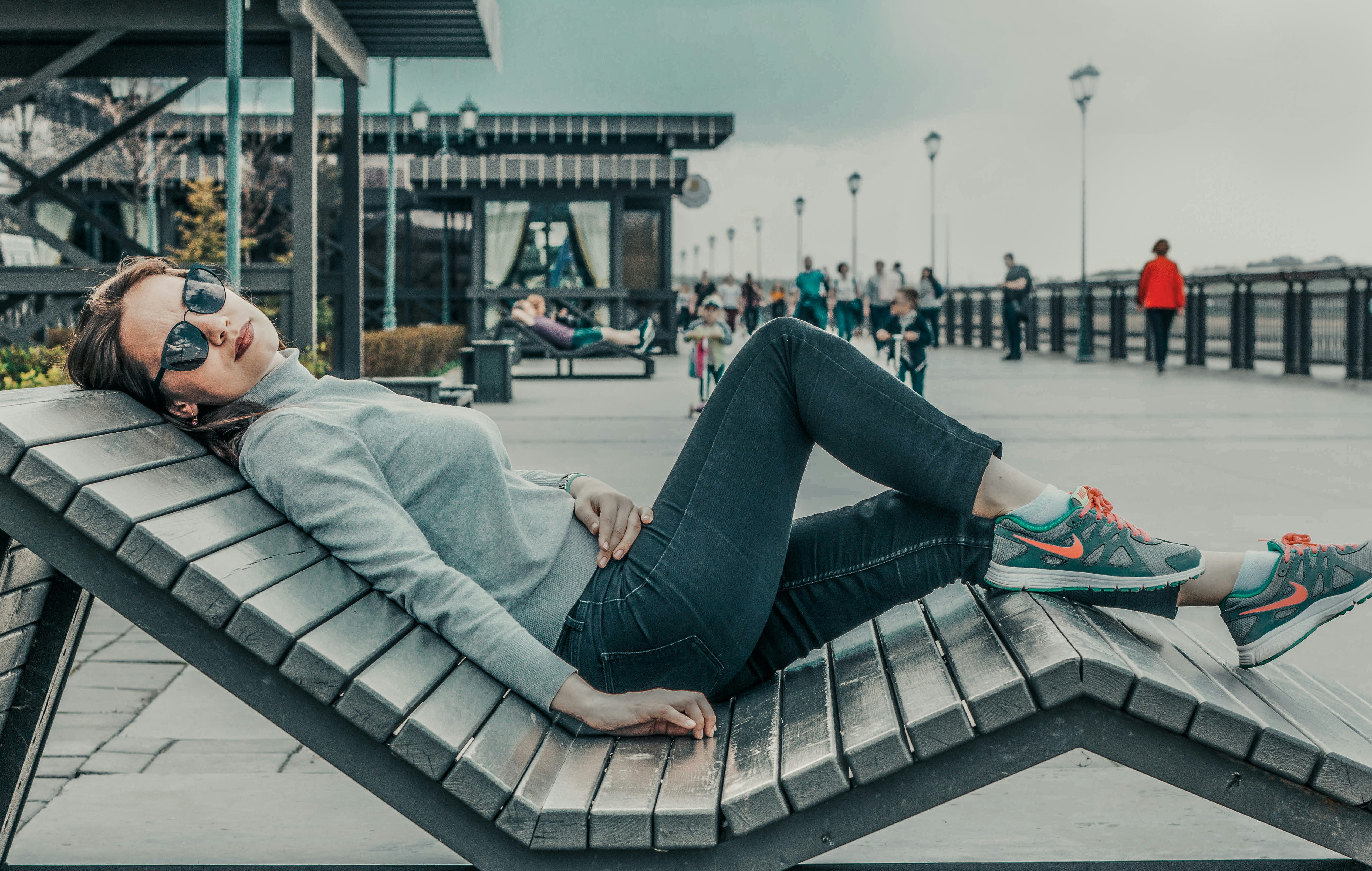 woman laying on bench during daytime