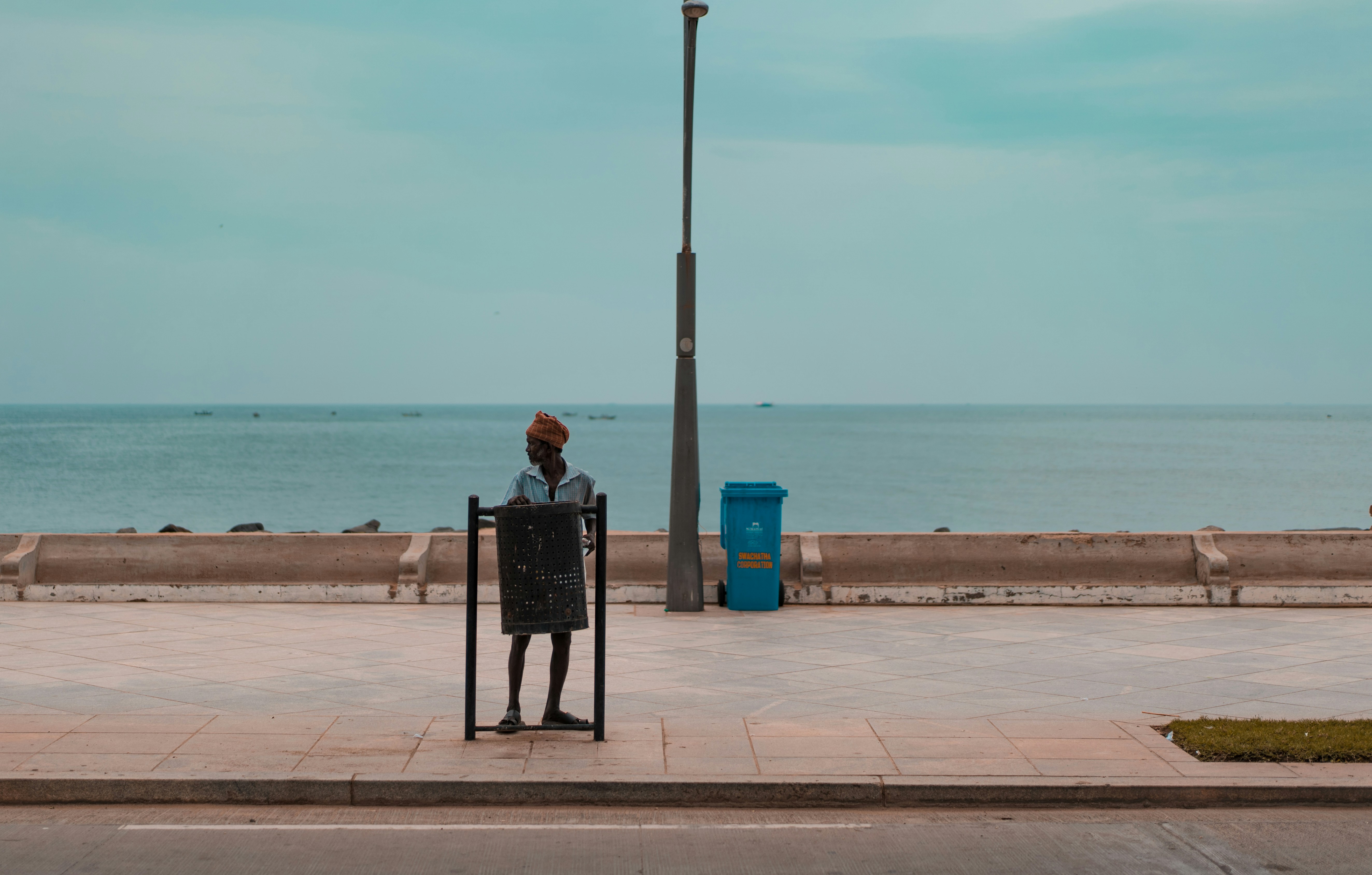 woman wearing blue shirt standing on sidewalk