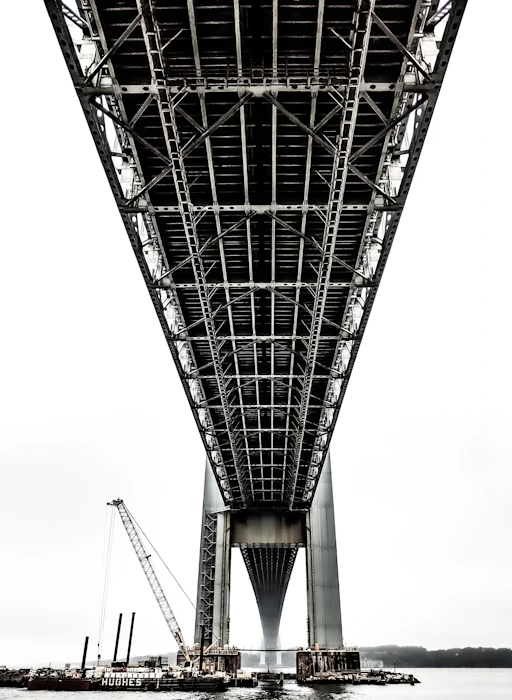 boats under black metal bridge at daytime