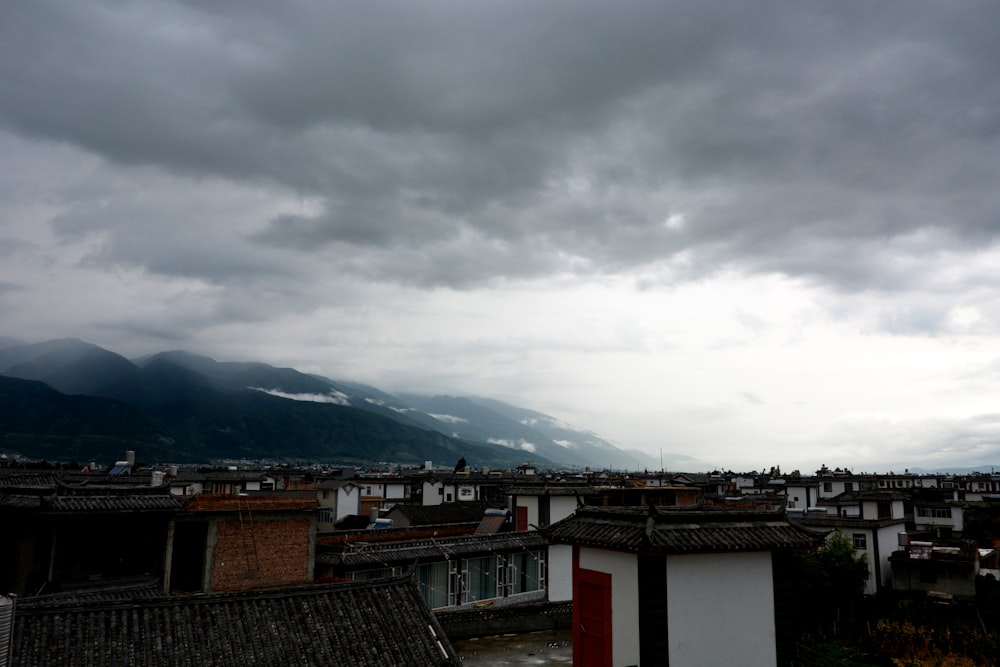 house lot near hill under white clouds during daytime