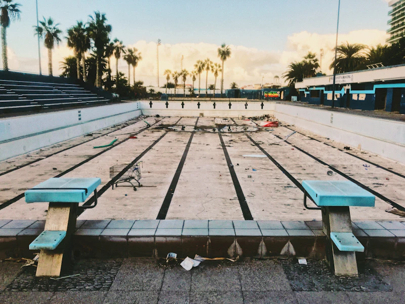 Drained, debris-covered pool sitting closed before its spring opening
