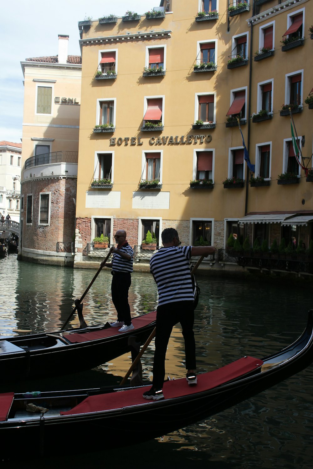 two person on a boat near brown building during daytime