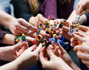 people holding miniature figures