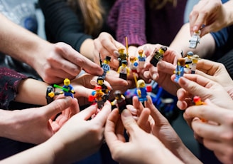 people holding miniature figures