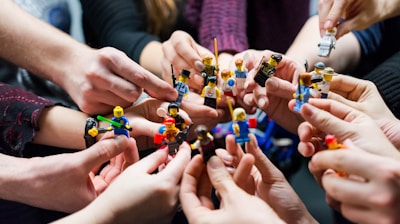 people holding miniature figures