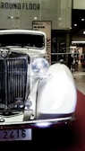 A classic vintage car displayed in a showroom with polished floors.