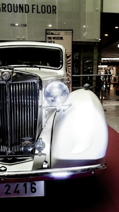 A classic vintage car displayed in a showroom with polished floors.