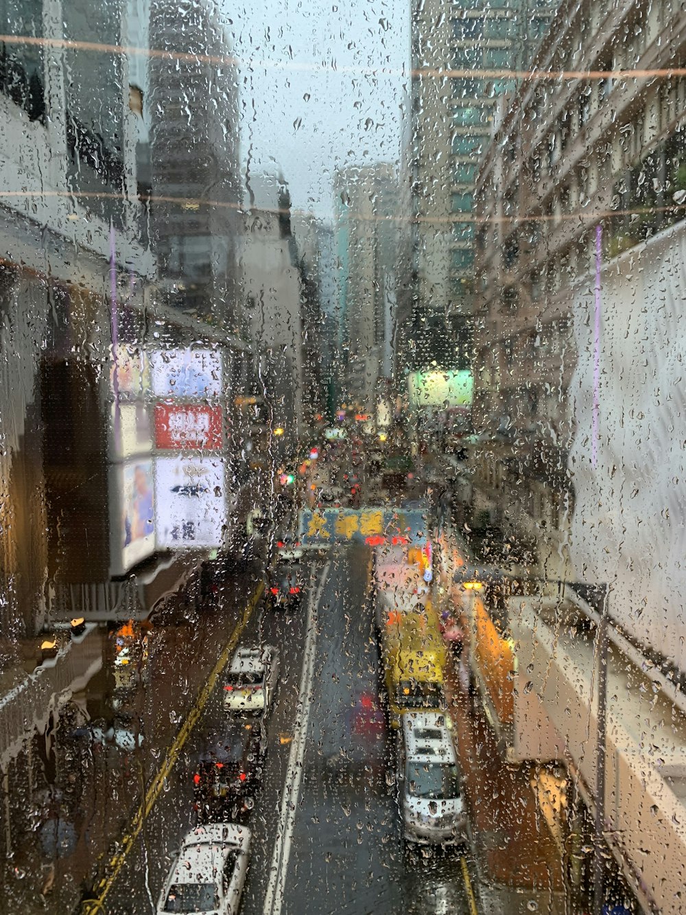 a view of a city street through a rain covered window