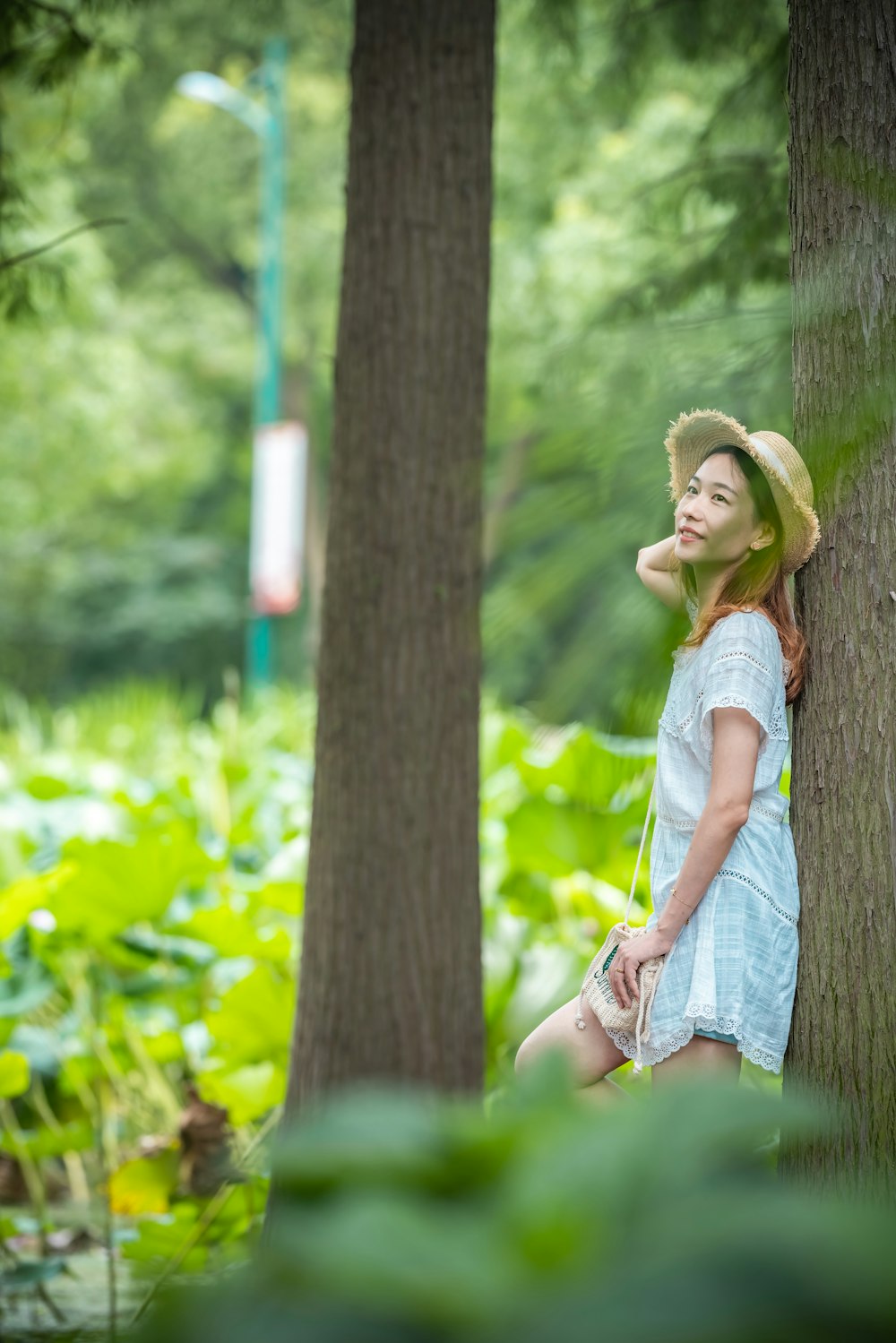 woman leans on tree