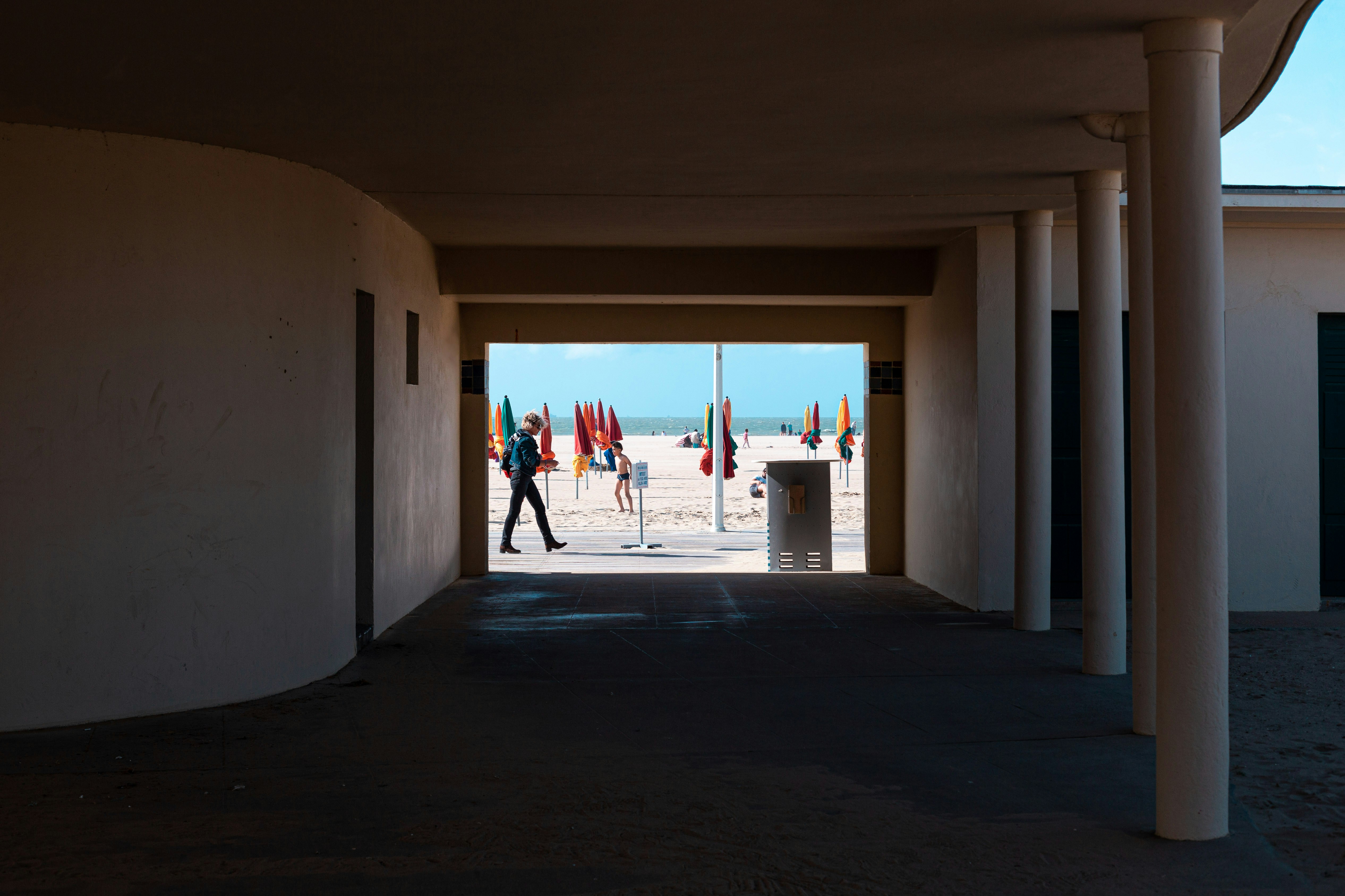 a person walking down a long hallway between two buildings
