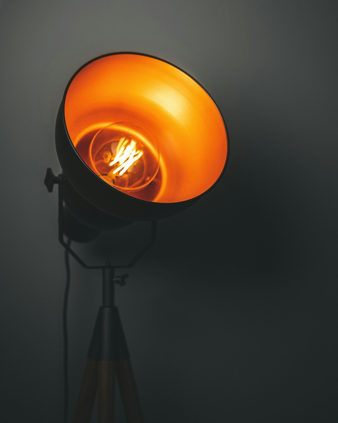 An industrial style lamp against a grey background. 