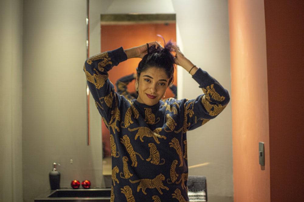 a woman standing in front of a bathroom mirror