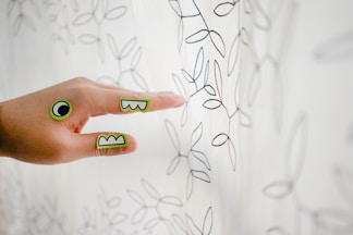 a person's hand pointing at a drawing on a wall