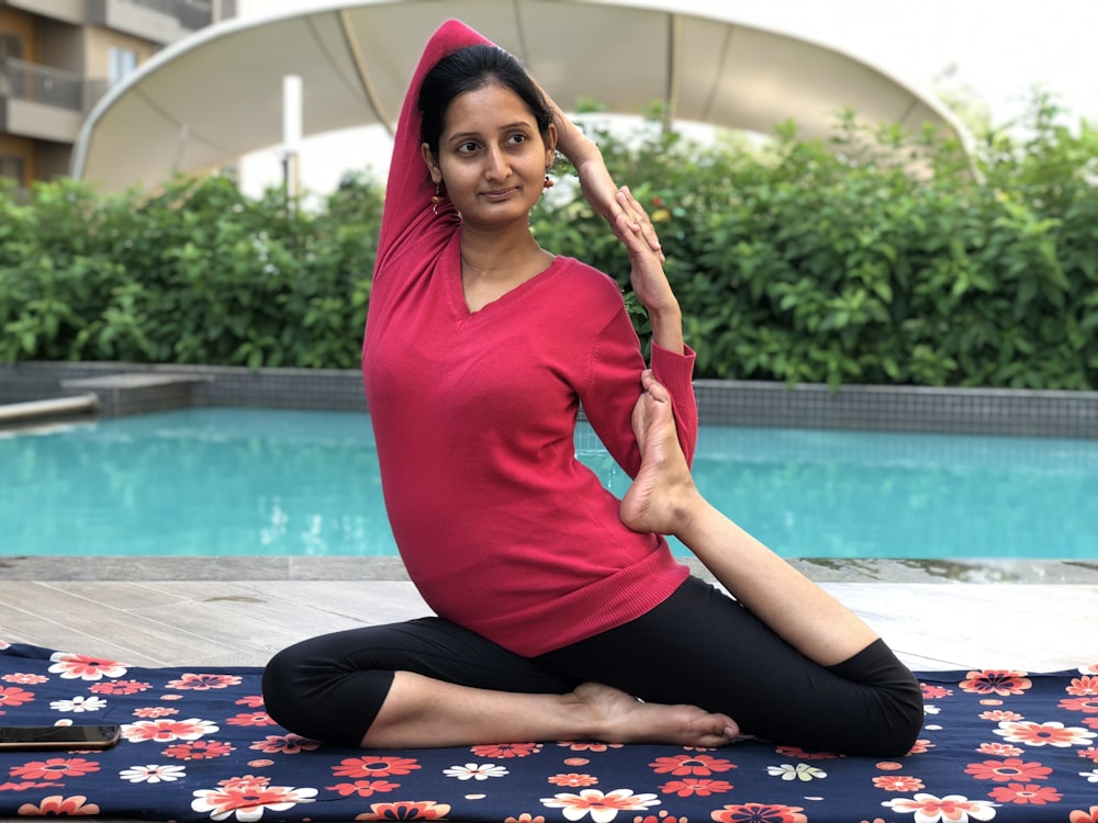 woman doing yoga near pool