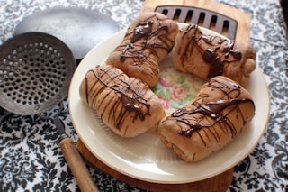 four breads with chocolate syrup on plate