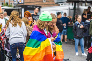 A warm, inviting photo of a group of bear community members chatting happily at an outdoor event.