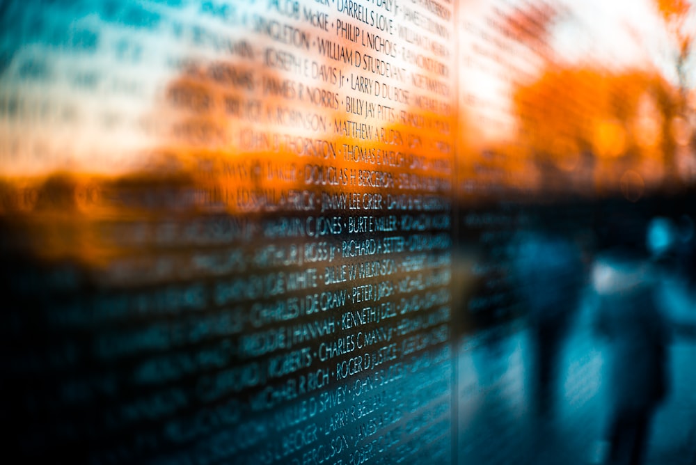 two people walking past a wall covered in words