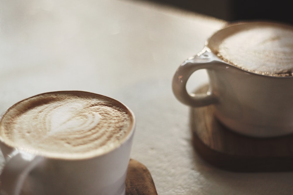 two white ceramic mugs on coaster