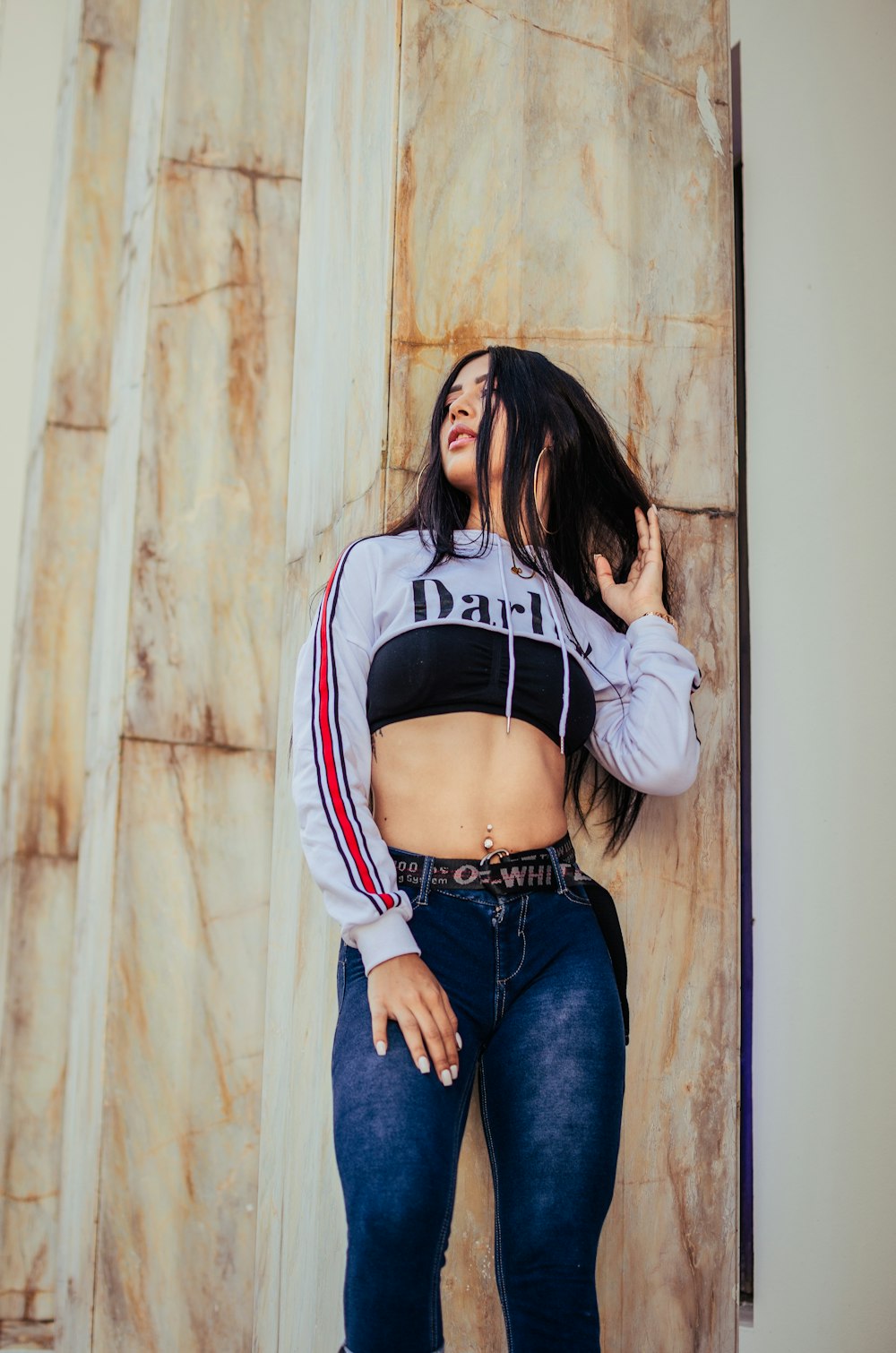 woman in white crop pullover hoodie and blue jeans