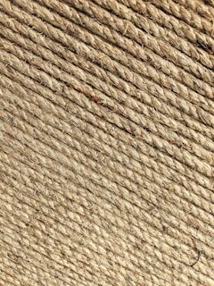 A close-up view of tightly wound beige rope coils, displaying a rough texture with visible fibers and strands.