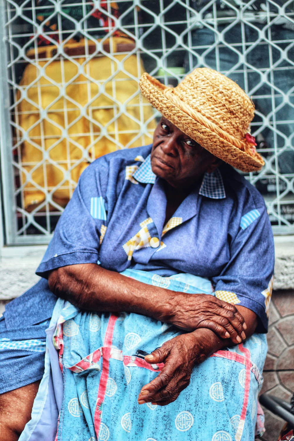 A woman sitting on a street in Bridgetown on an ordinary day