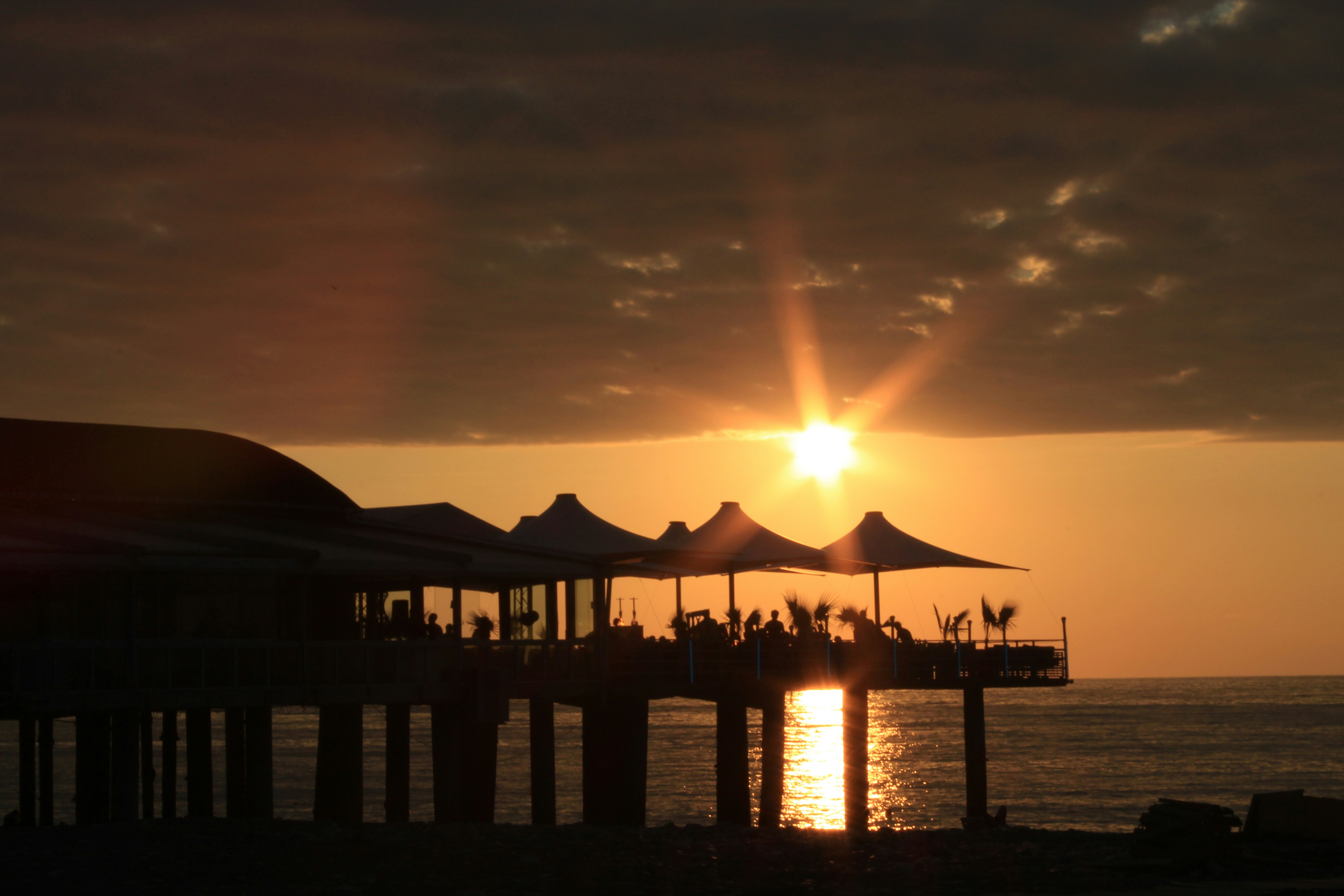 silhouette of beach house under orange skies, Sunset at Batumi Beach