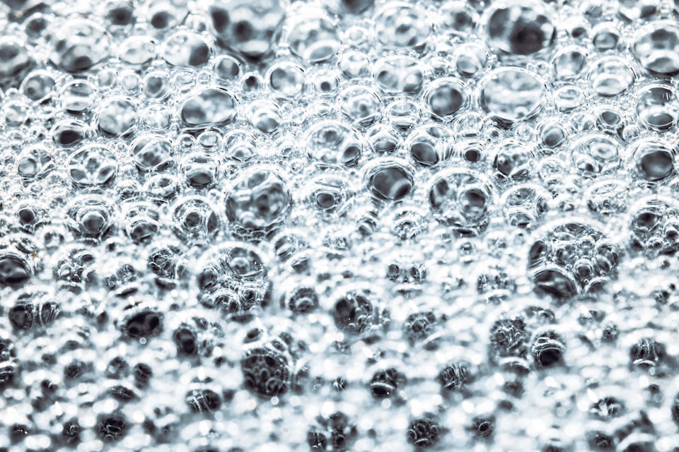 Close-up view of suspended water droplets creating an abstract pattern against dark gray background