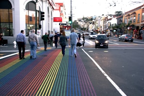 A group of friends wearing Lumina Apparel pieces, laughing and crossing a city crosswalk.
