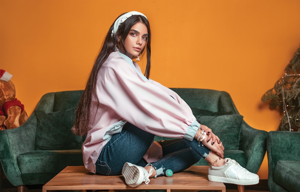 a woman sitting on a coffee table in front of a couch