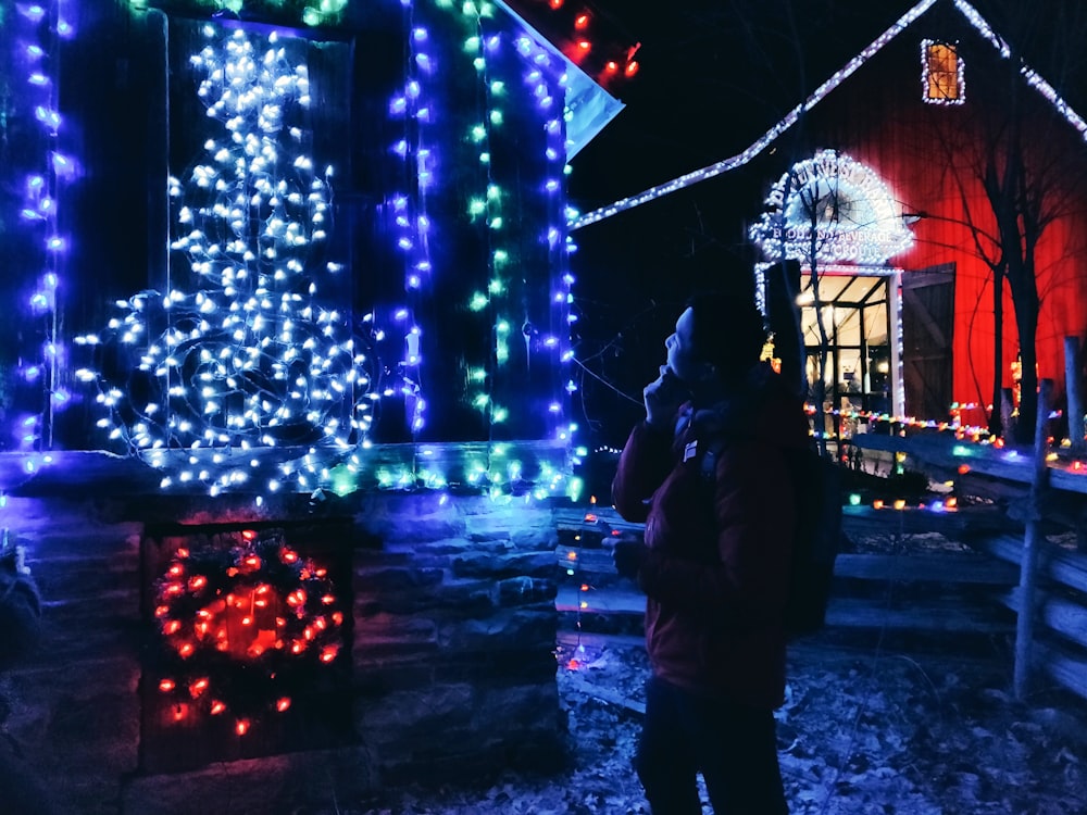 man standing in front of string lights during nighttime