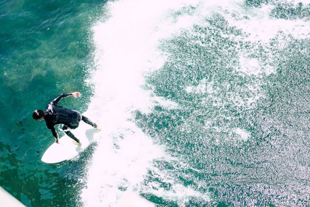 Homem montando prancha de surf durante o dia