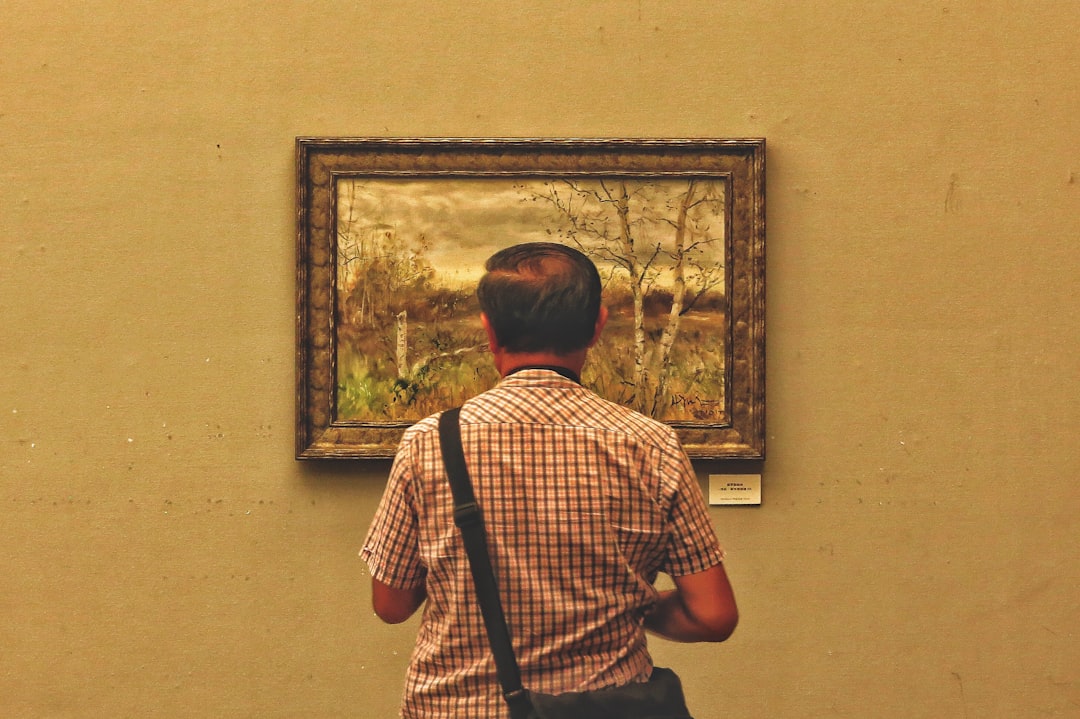 man standing facing painting
