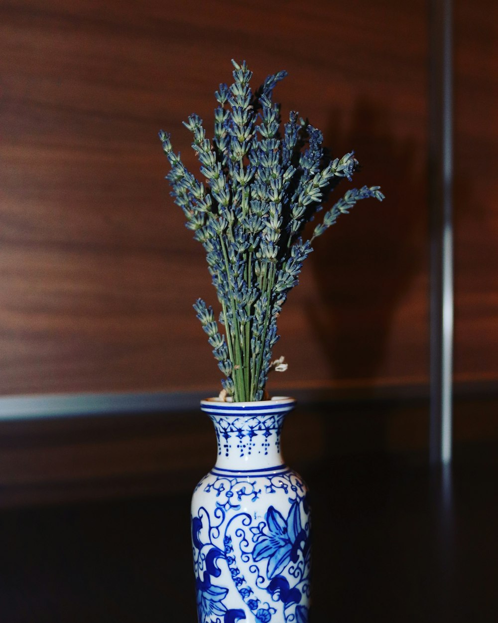 a blue and white vase with a plant in it