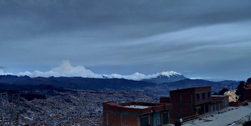 brown buildings near snow-capped mountain