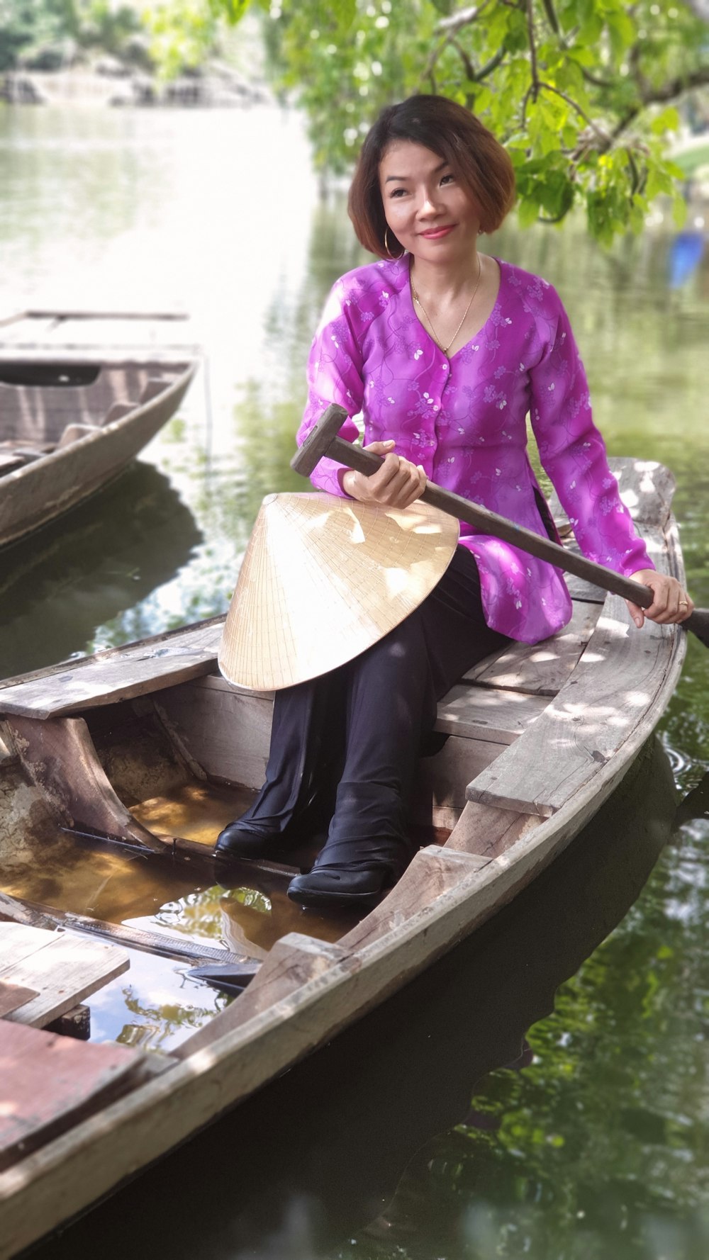 woman paddles wooden boat