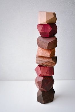 A casual stacking game screenshot featuring colorful blocks being balanced.