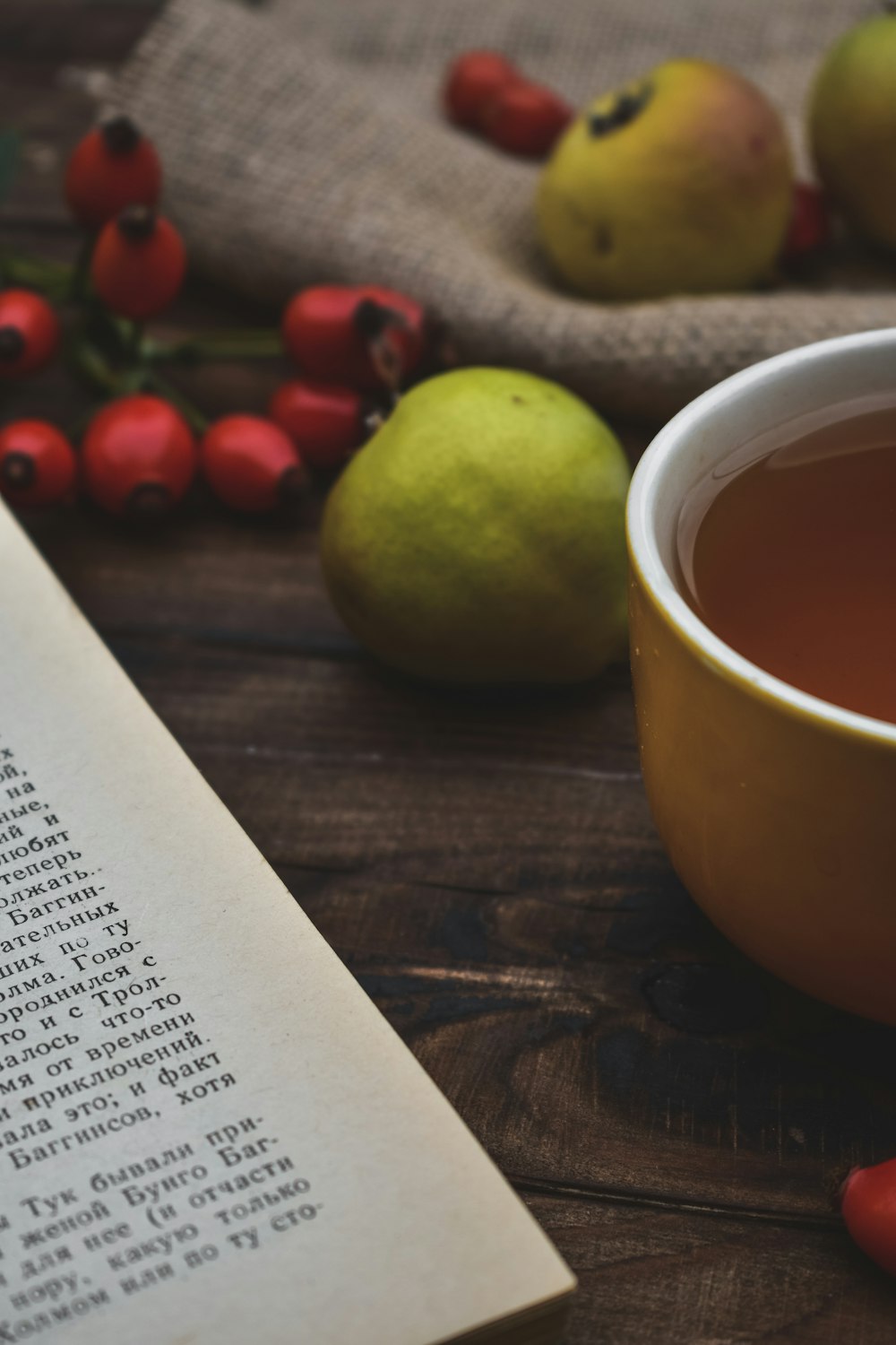 filled cup near fruits and book