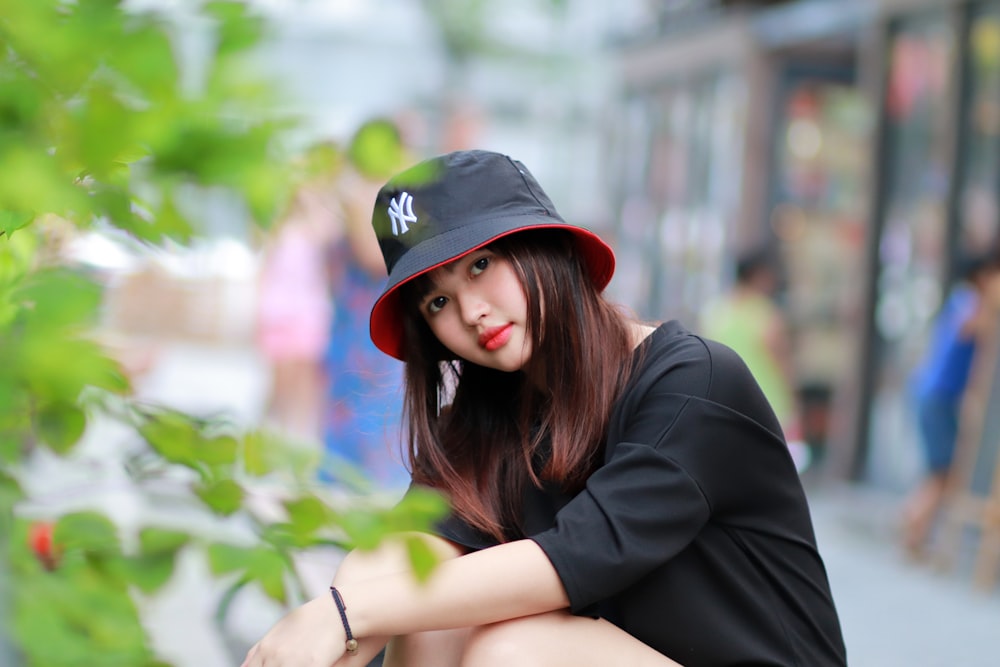 photo of woman wearing black shirt and black New Yankees bucket hat