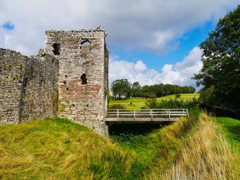 green grassland besides castle wall during daytime