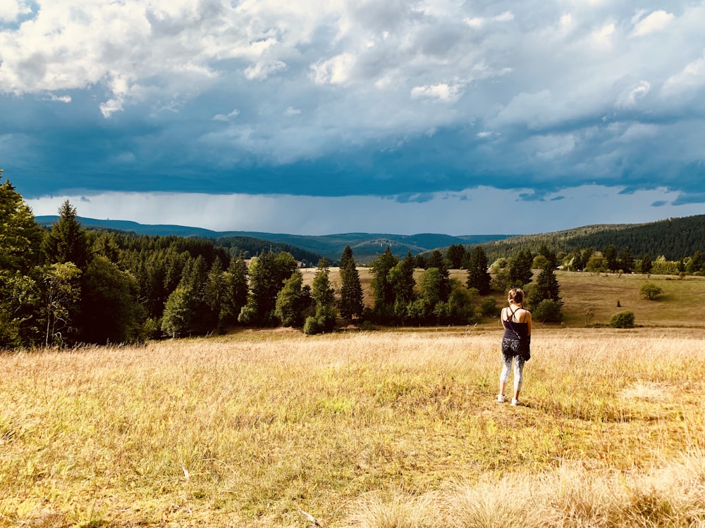 woman in black top standing on grass field