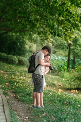 A couple quietly observing birds with binoculars surrounded by nature.