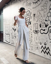 woman holding cup walking beside wall