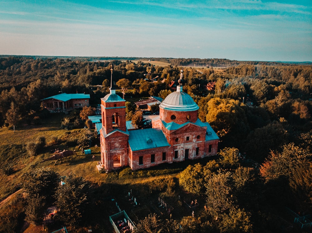 Igreja bege e teal perto da floresta durante o dia