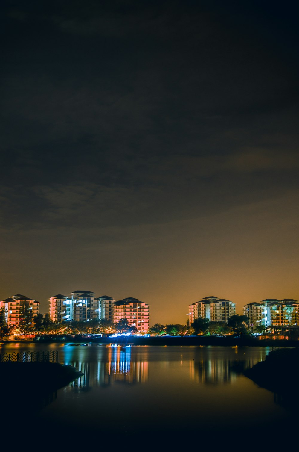 reflection of city skyline on body of water during nighttime