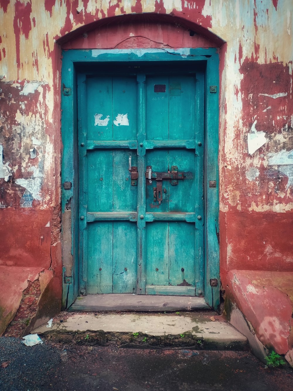 Edificio de hormigón marrón con puerta cerrada de madera azul