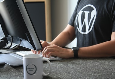 person in black and white t-shirt using computer