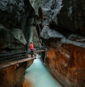 man looking upward while standing in front of balustrade inside tunnel