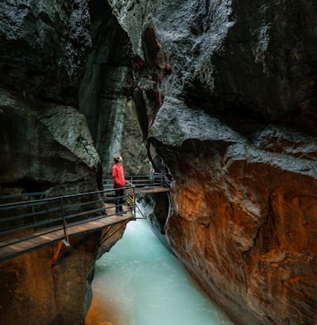 man looking upward while standing in front of balustrade inside tunnel
